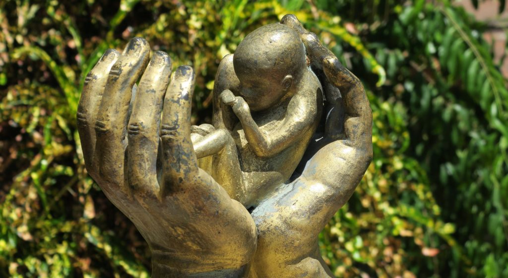 hands protecting the unborn infant